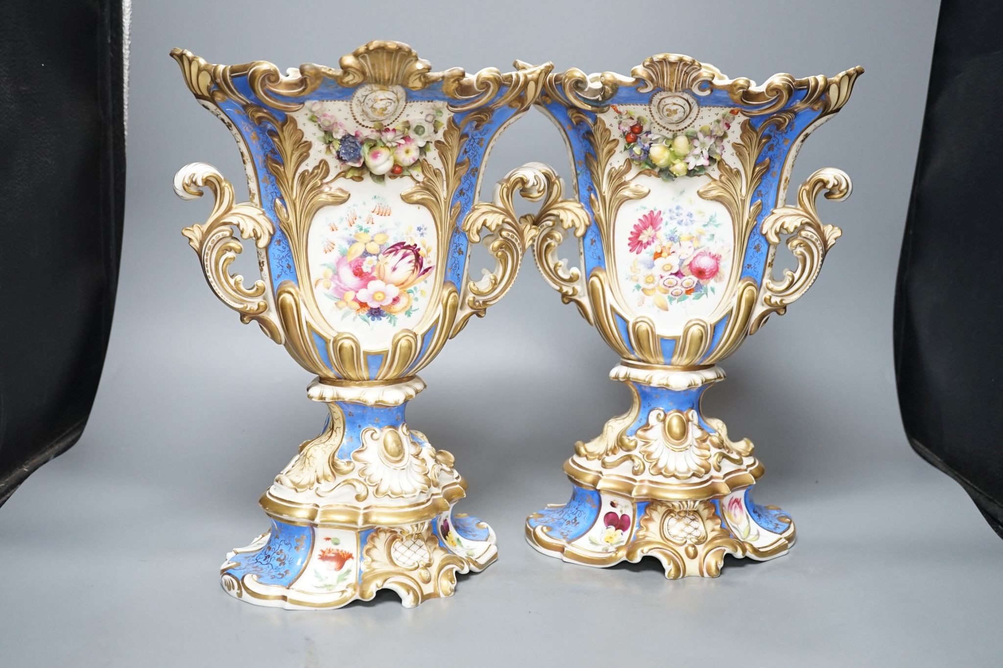 A large pair of 19th century Grainger & Co. vases with scenes of Worcester and Malvern on a blue ground, 34 cms high.